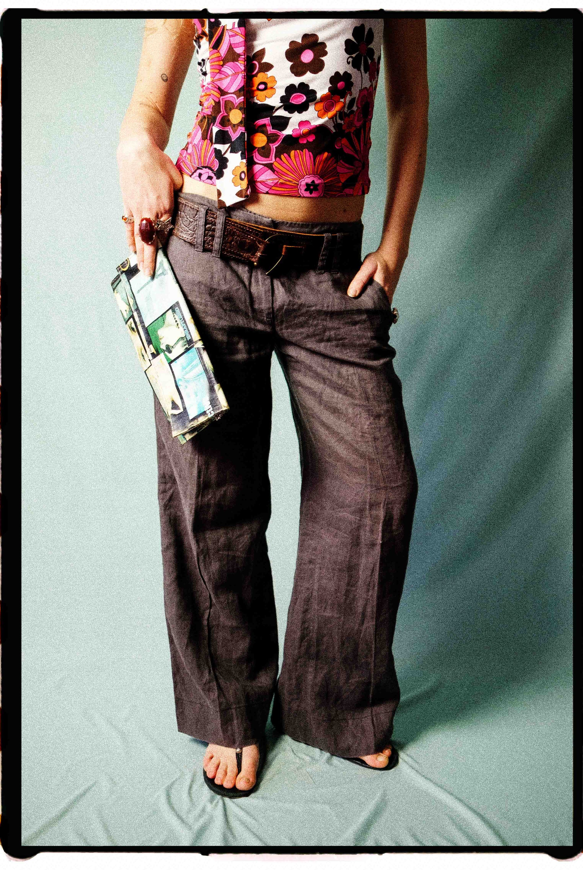 Close-up of taupe linen trousers showing front pockets and oversized belt loops